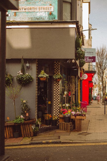 A floral display outside a flower shop on Carnaby Street Soho featuring a bouquet arrangement of fresh flowers including pink roses, yellow daisies, and purple statice, arranged in a clear glass vase 