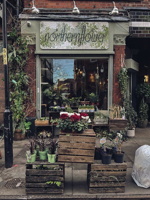 The exterior of 'northernflower,' a flower shop on Carnaby Street Soho, showcasing an inviting display of fresh flowers and plants arranged on rustic wooden crates outside. The arrangement features a 